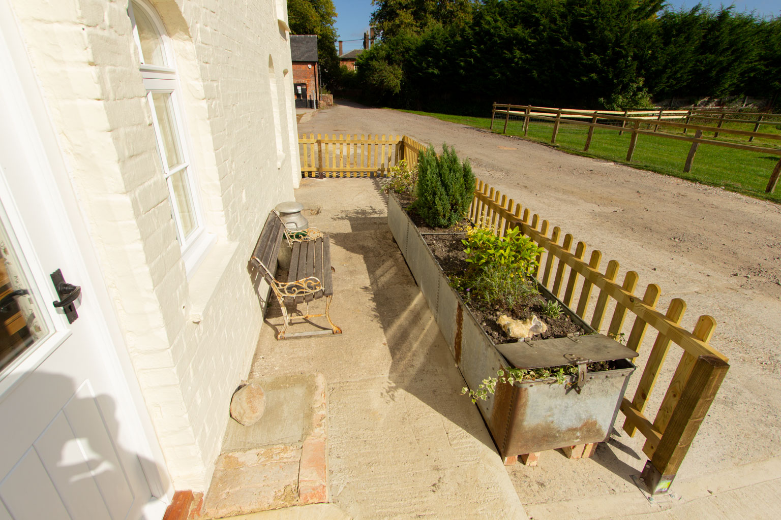 The perfect bench for your morning coffee with our farm fashioned flowery water trough.